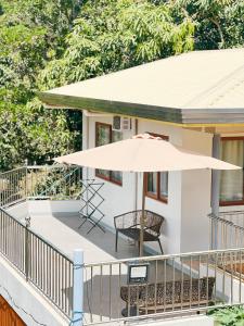 a patio with an umbrella and a chair on a house at Who's Gloria in El Nido
