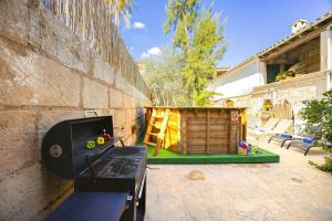 a outdoor kitchen with a grill and a wooden shed at Casa de Can Virolla Gran in Sa Pobla