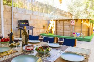 a table with plates and wine glasses and a playground at Casa de Can Virolla Gran in Sa Pobla