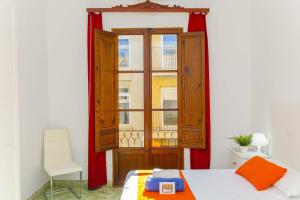 a bedroom with a window and a bed and a chair at Casa de Can Virolla Gran in Sa Pobla +43 photos