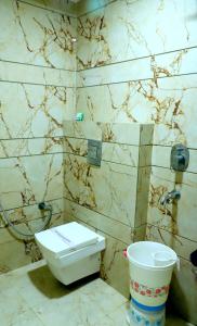 a bathroom with a toilet and a bucket at The Charlie Backpackers in New Delhi