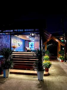 a building with stairs and potted plants in front of it at Hưng Phát Hotel 2 - Gadren in Phú Lợi