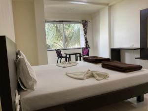 a bed in a room with a table and chairs at The Hotel Relax in Kankauli
