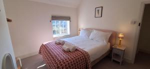 a bedroom with a bed with two towels on it at Rose Cottage in Docking