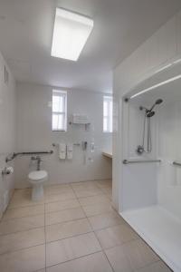 a white bathroom with a toilet and a sink at Ramada by Wyndham Jersey City in Jersey City +25 photos