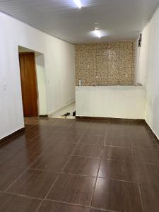 an empty room with a white wall and a tile floor at Casa para MotoGP in Goiânia