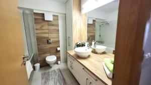 a bathroom with two sinks and a toilet and a mirror at Riella Home in Szombathely