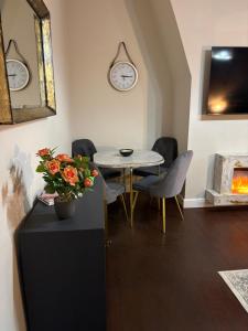 a dining room with a table and chairs and a clock at Grosvenor 126 Trendy Jesmond Whole Apartment in Jesmond