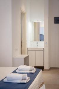 ein weißes Badezimmer mit zwei Handtüchern auf einem Bett in der Unterkunft Afissos Blu Hotel in Áfissos
