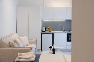 ein Wohnzimmer mit Sofa und eine Küche in der Unterkunft Afissos Blu Hotel in Áfissos