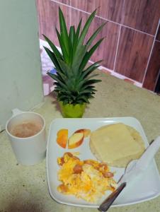 a plate of food with cheese and fruit on a table at Hotel Coralite Suites Santa Marta in Santa Marta