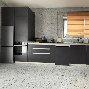 a kitchen with stainless steel appliances and black cabinets at Houefa home résidence in Cotonou