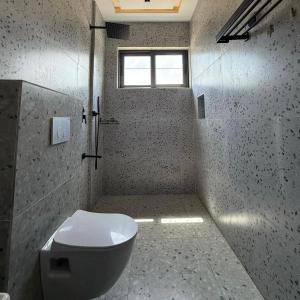 a bathroom with a toilet and a window at Houefa home résidence in Cotonou +6 photos