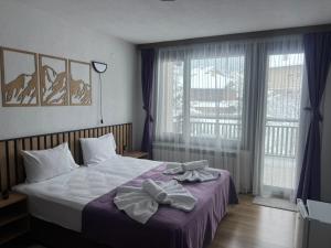 a bedroom with a bed with bows on it at Guest House Raffe in Dobrinishte