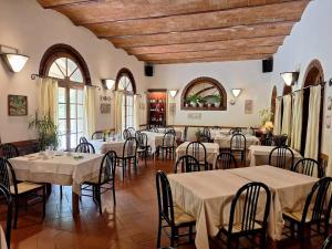 a restaurant with tables and chairs in a room at Molino D'Era Country Hotel in Volterra