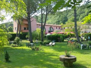 a park with tables and chairs in the grass at Molino D'Era Country Hotel in Volterra