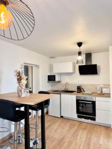 a kitchen with white cabinets and a wooden table at Chez Jacob, Centre de Rennes in Rennes