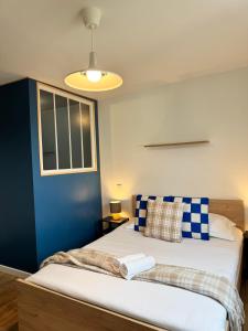 a bedroom with a bed with a blue wall at Chez Jacob, Centre de Rennes in Rennes