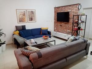 a living room with a couch and a brick wall at Sava & Double Rooms in Prijedor