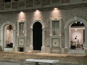 a brick building with a black door and a bench at Casa MauRo in Senigallia