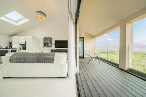 a bedroom with a bed and a balcony with a kitchen at Washington Beach House in Heacham