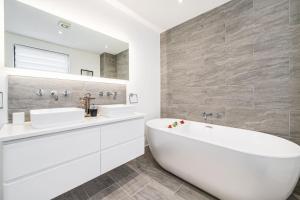 a white bathroom with two sinks and a tub at Washington Beach House in Heacham +30 photos
