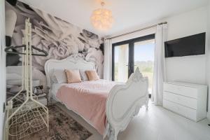 a bedroom with a white bed and a wall mural at Washington Beach House in Heacham