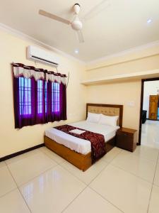 a bedroom with a bed and a purple window at MG Elite Residency in Pondicherry +20 photos