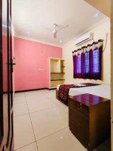a bedroom with a bed and a red wall at MG Elite Residency in Pondicherry