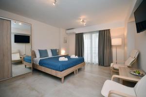 a bedroom with a blue bed and a living room at Pietra Sole Residences in Ierapetra