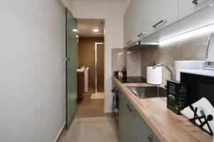 a small kitchen with a sink and a shower at Pietra Sole Residences in Ierapetra +39 photos