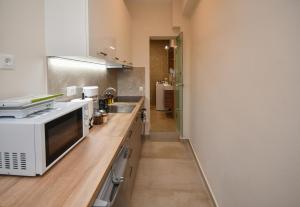 a kitchen with a white microwave and a sink at Pietra Sole Residences in Ierapetra
