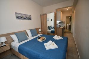 a bedroom with a blue bed with towels on it at Pietra Sole Residences in Ierapetra