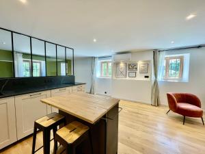 a large kitchen with a wooden table and chairs at Mont Pellat - Spacieux studio au Charme Unique in Bassens +20 photos