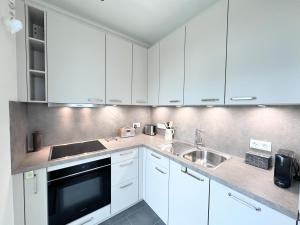 a kitchen with white cabinets and a sink at FeWo RoSi SN in Schwerin