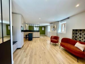 a living room with a red couch and a kitchen at Mont Pellat - Spacieux studio au Charme Unique in Bassens