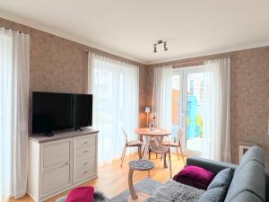 a living room with a couch and a flat screen tv at FeWo RoSi SN in Schwerin