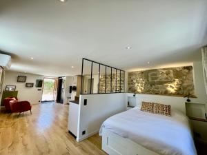 a bedroom with a white bed and a red chair at Mont Pellat - Spacieux studio au Charme Unique in Bassens