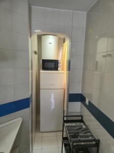 a small kitchen with a refrigerator and a microwave at Bajondillo Beach Apartment By Torremolinos On-line in Torremolinos +37 photos