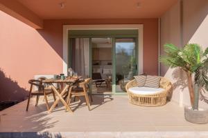 a patio with a table and chairs and a palm tree at Ionian Nest Studio in Pogoniá