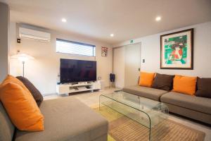 a living room with a couch and a flat screen tv at Bito Petrip hotel 美都ペットリップホテル #LP1 in Tuyama