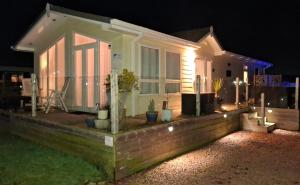 a small house with plants in the front yard at night at 21 Hesket Park HUGE HOT TUB Pet friendly No Commercial Vans in High Hesket +10 photos