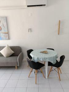 a table and chairs in a living room with a couch at Bajondillo Beach Apartment By Torremolinos On-line in Torremolinos