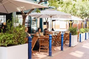 a group of people sitting at a restaurant under umbrellas at Charles Hope Boutique Hometel in Cape Town