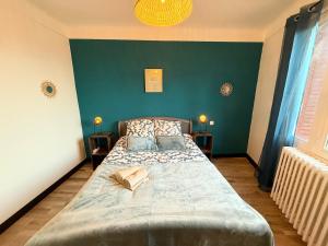 a large bed in a room with a green wall at Appartement, centre, cozy in Rodez