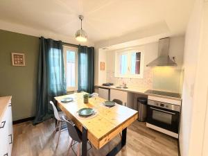 a kitchen with a wooden table and a dining room at Appartement, centre, cozy in Rodez +20 photos