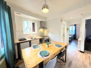 a kitchen with a wooden table with chairs in it at Appartement, centre, cozy in Rodez