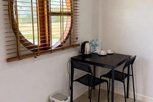 a black table and chairs in a room with a window at The 9 Motel in Ngao