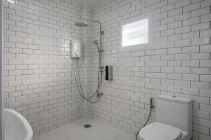 a bathroom with a shower and a toilet and a sink at The 9 Motel in Ngao +8 photos
