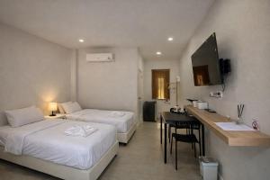 a hotel room with two beds and a counter with a sink at The 9 Motel in Ngao
